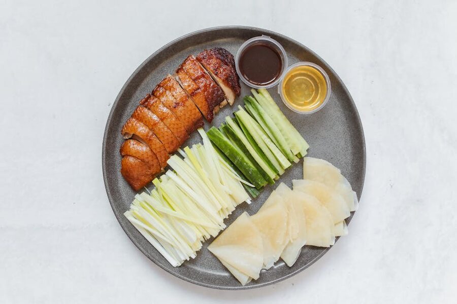 Plate of Peking duck with cucumber, onion, and sauce
