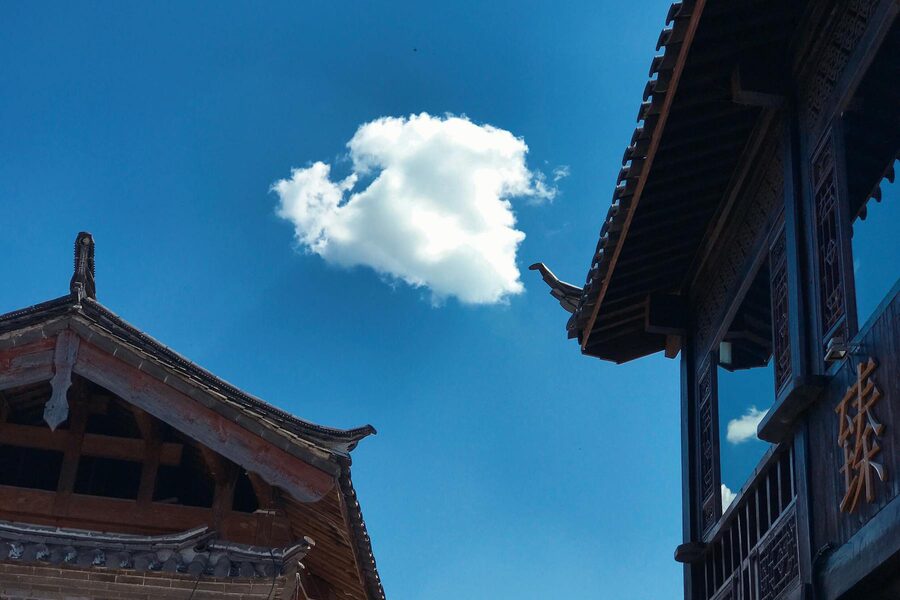 Traditional Chinese rooftops against blue sky in Lijiang