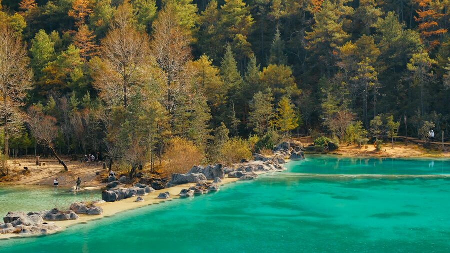 Turquoise lake surrounded by autumn foliage near Lijiang