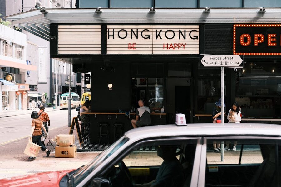 Hong Kong street scene with cafe storefront and passing traffic