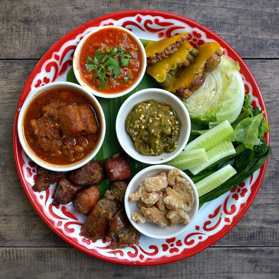 Lanna starter platter with nam prik ong, nam prik num, pork rinds, vegetables and sticky rice in Chiang Mai