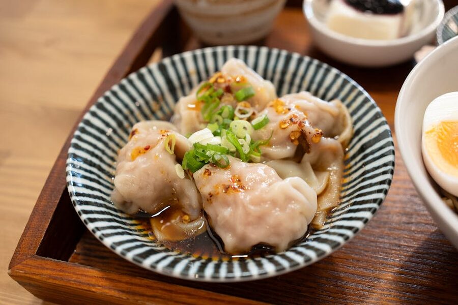 Chinese dumplings served with soy sauce scallions and chili oil dipping sauce
