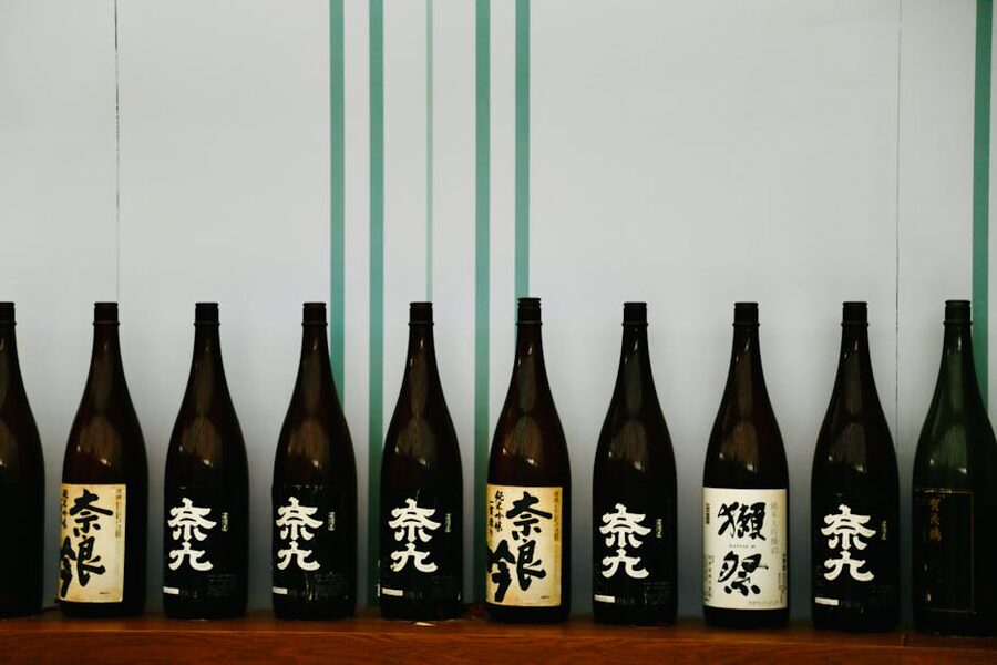 A row of Japanese sake bottles displayed on a wooden shelf