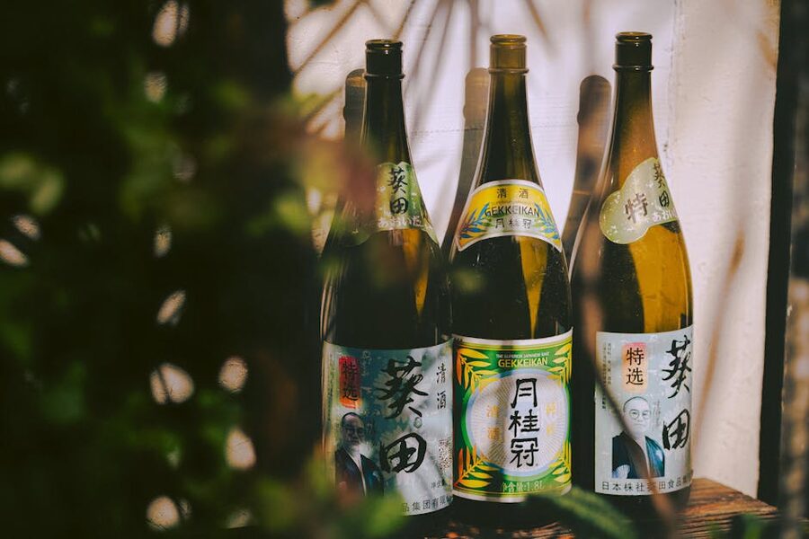 Three traditional Japanese sake bottles with labels in natural light