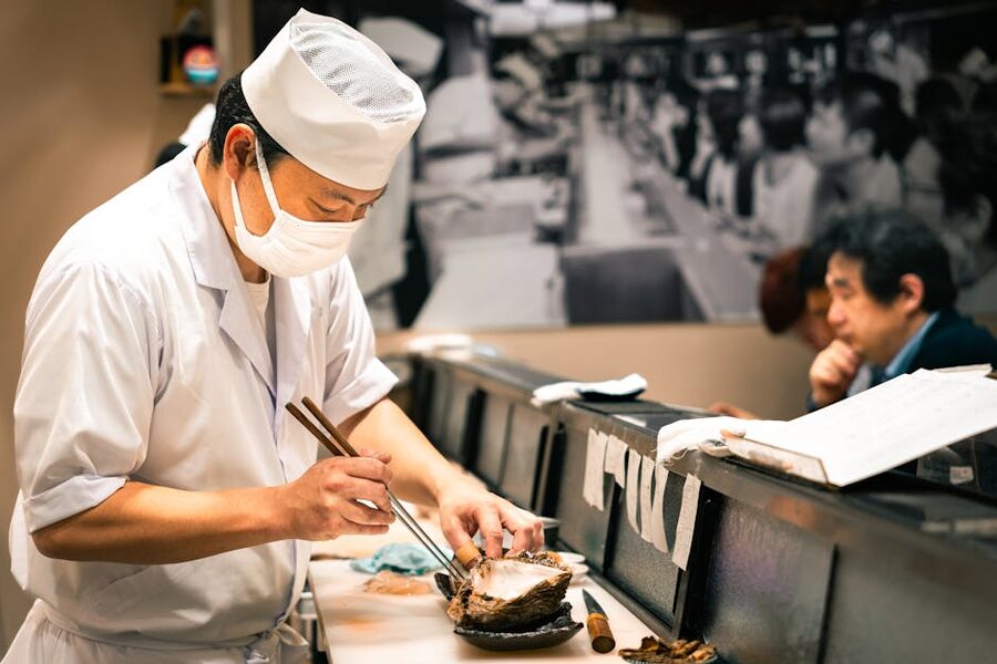 A sushi chef preparing fish at a counter in Tokyo