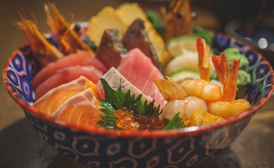 A chirashi bowl featuring fresh seafood and garnishes