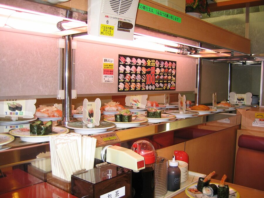 Plates of sushi moving along a kaiten conveyor belt