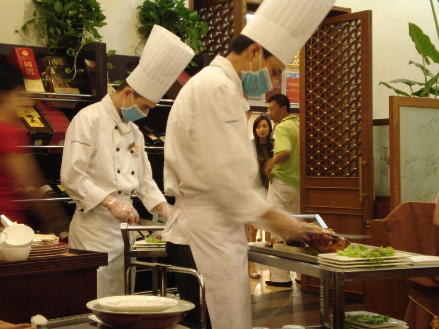 Chef carving a Peking duck at a traditional Beijing restaurant