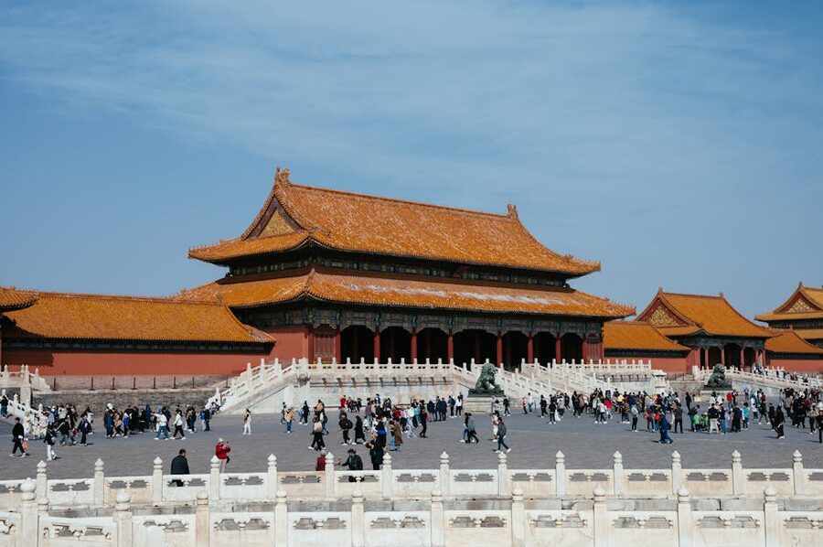 Tourists exploring Forbidden City courtyard with traditional Chinese architecture