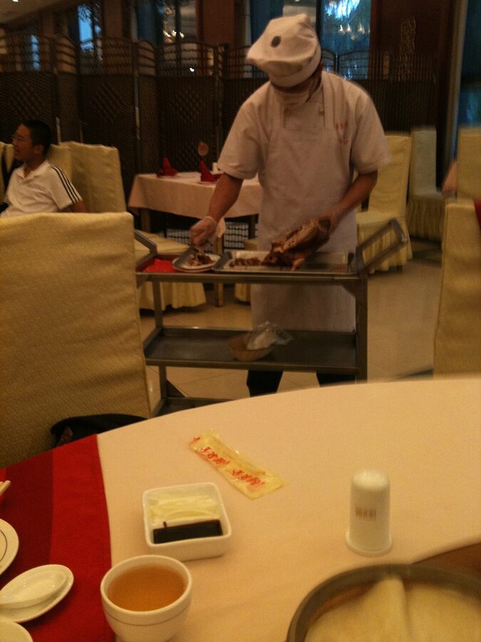 Chef carving Beijing roast duck at Quanjude restaurant