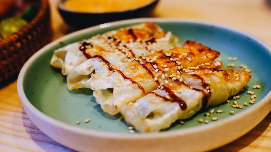 Plate of pan-fried Japanese gyoza dumplings with dipping sauce