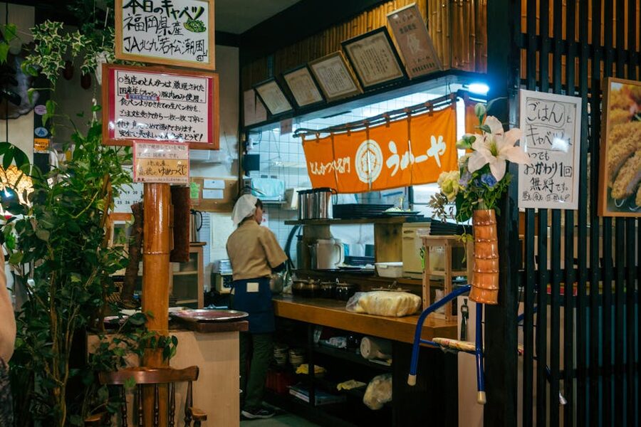 Man standing at a yatai food stall bar counter in Fukuoka