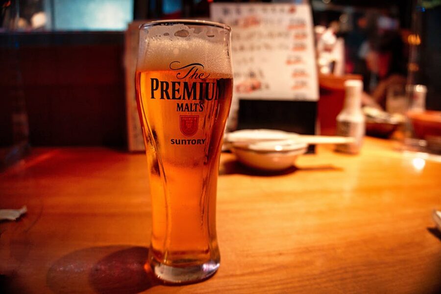 Close-up of a cold Japanese lager beer in a tall glass inside a Tokyo izakaya
