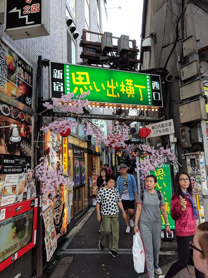 Narrow entrance to Omoide Yokocho alley in Shinjuku with hanging signs and red lanterns