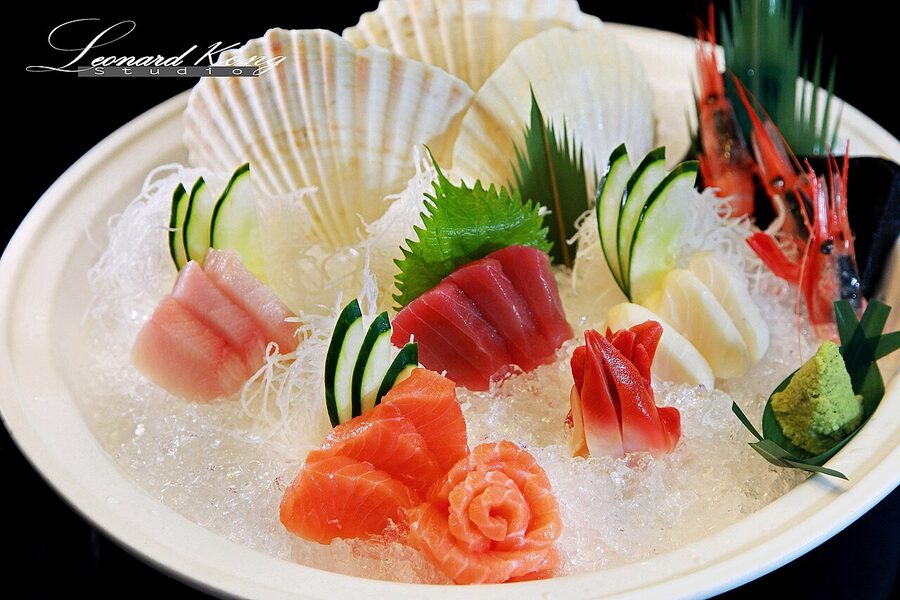 Sashimi moriawase assorted platter with tuna, salmon, yellowtail and white fish on a wooden board