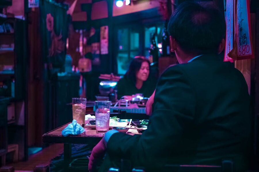 A diner in a Tokyo izakaya sitting at a table with food and drink