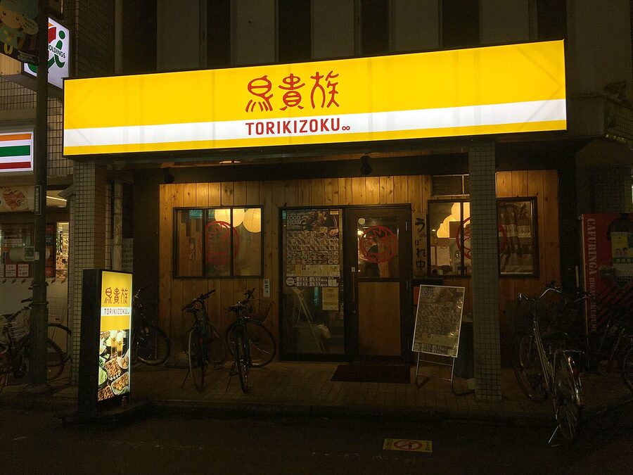 Torikizoku chain izakaya exterior with yellow and red signage