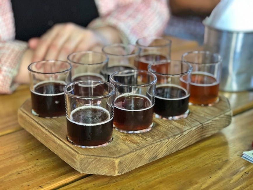 Assortment of craft beers in different glassware on a rustic wooden serving tray