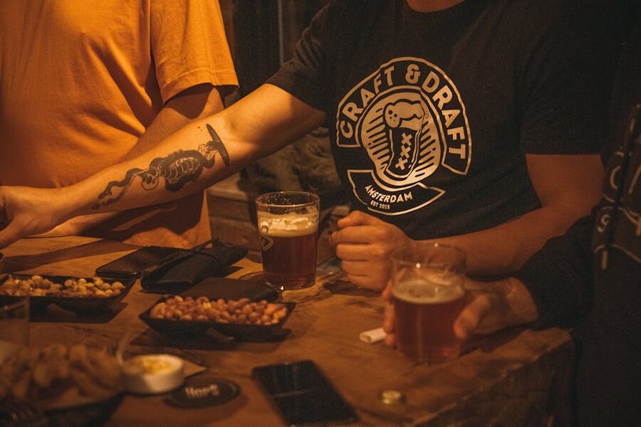 Friends sharing craft beer and small plates of food at a Japanese pub table