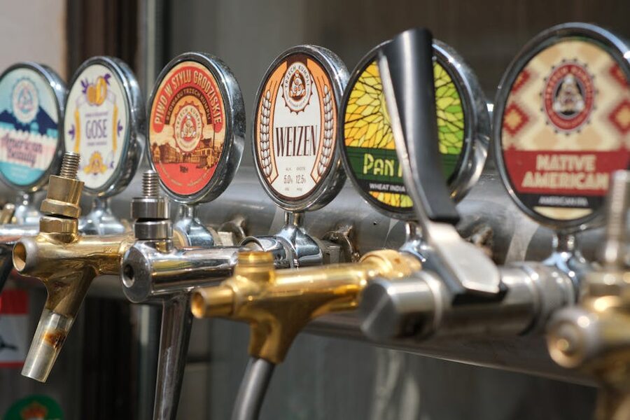 Close-up of craft beer taps with various Japanese brewery labels in a bar