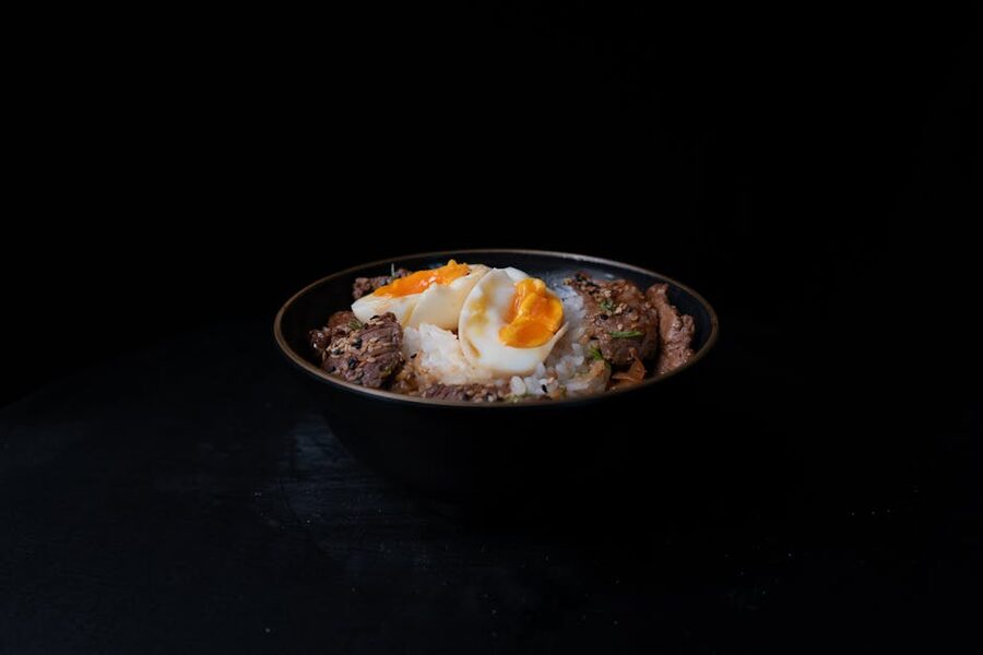 A beef donburi rice bowl topped with a soft-boiled egg