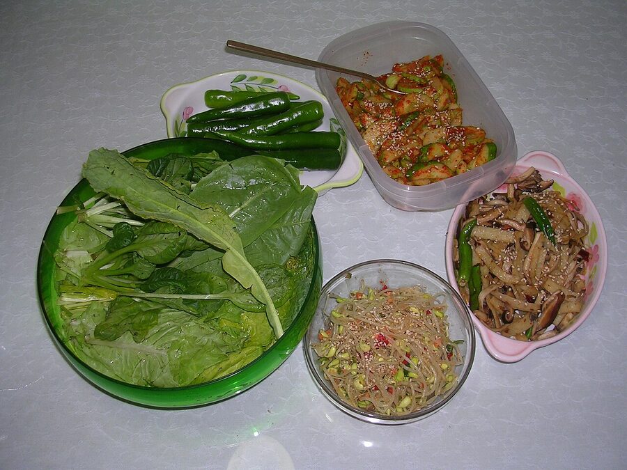 Korean banchan and ssam wraps laid out for a barbecue meal