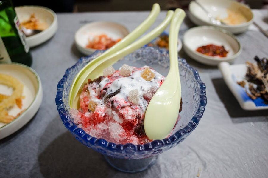 A colorful Korean bingsu dessert with shaved ice and spoons
