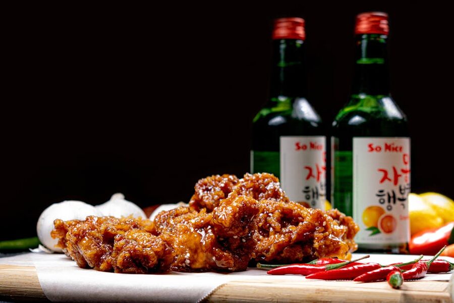 Korean fried chicken with soju bottles and chili peppers on a table