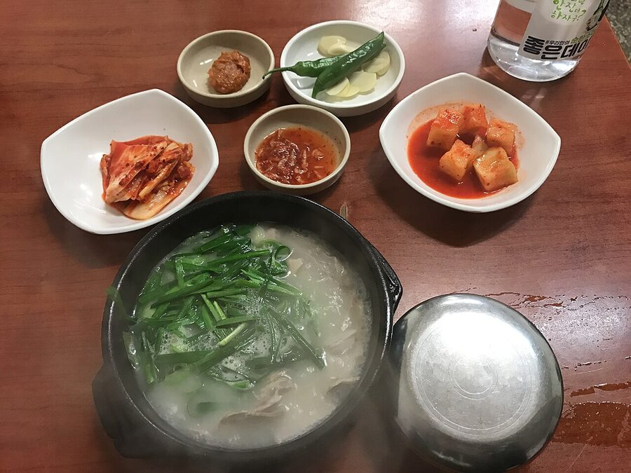 Busan-style dwaeji gukbap pork soup with rice and banchan