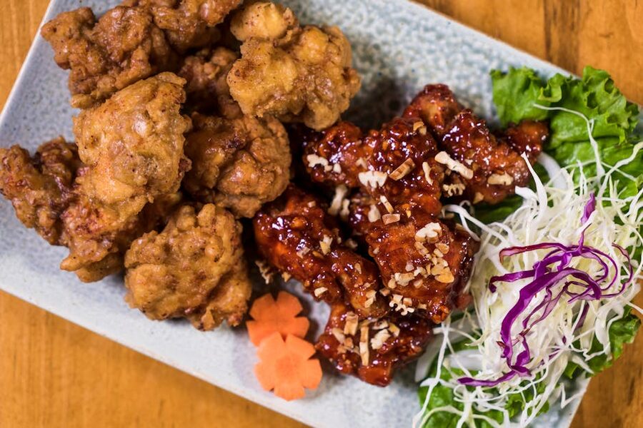 A plate of Korean fried chicken with fresh salad and garnishes