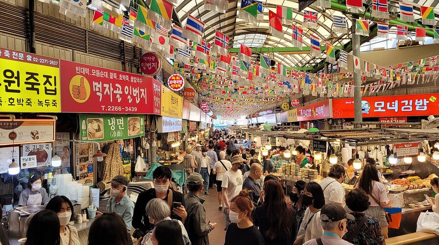 Food stalls at Gwangjang Market with diners eating at counters