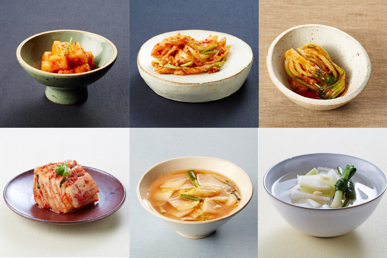 A selection of different types of kimchi on a wooden table