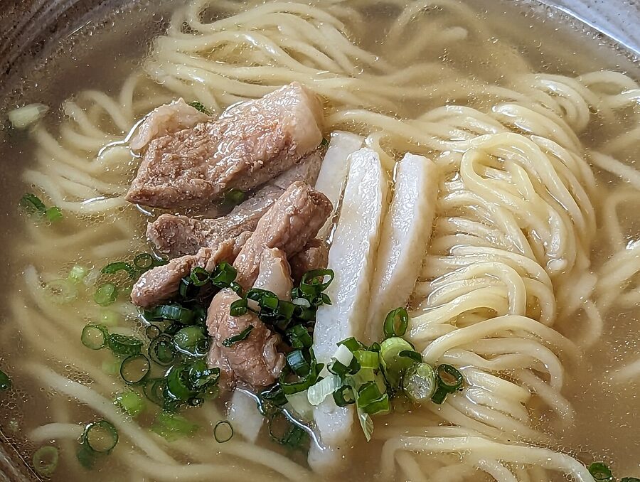 Bowl of Okinawa soba with thick wheat noodles pork belly and spring onion