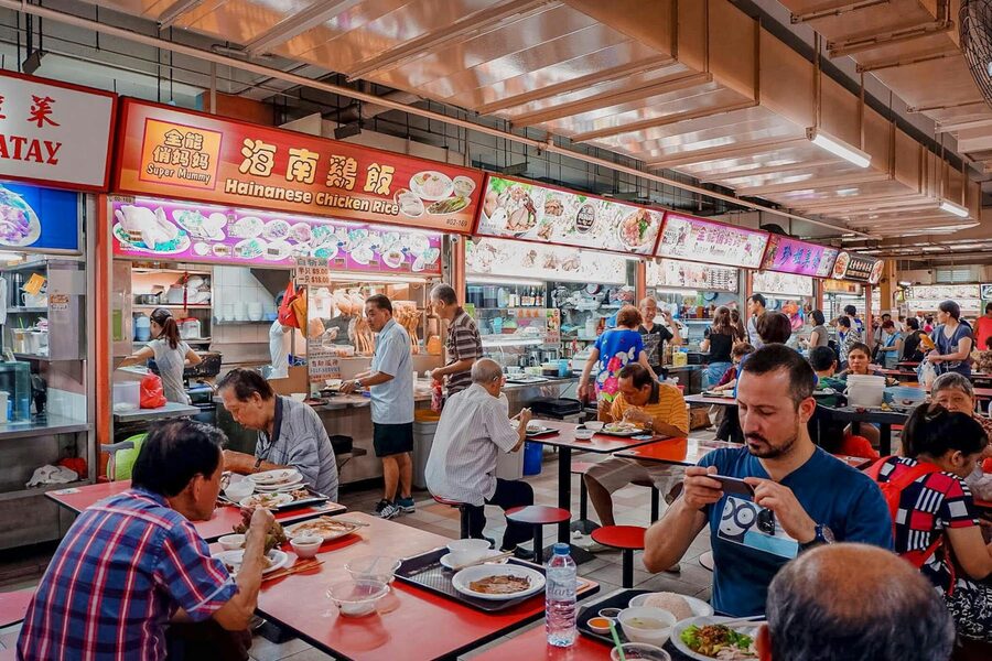 Singapore hawker centre interior with Hainanese chicken rice stalls