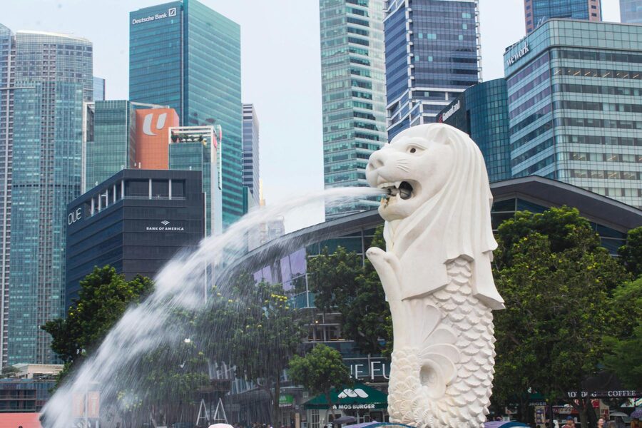 Merlion statue with flowing water and Singapore skyline