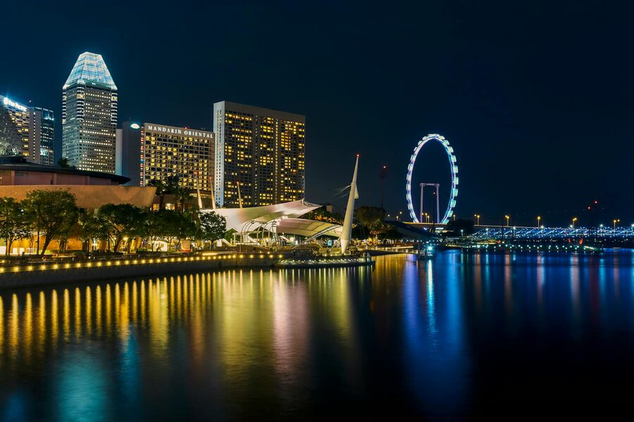 Singapore skyline illuminated at night with lights reflecting on water