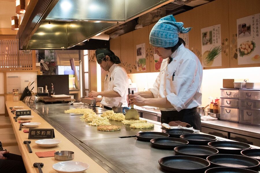 Okonomiyaki chef cooking on teppan griddle