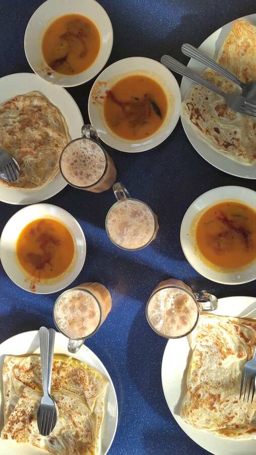 Roti canai with curry and teh tarik Malaysian breakfast