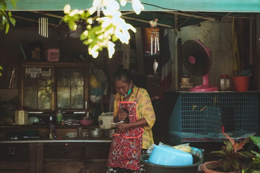 Elderly Thai woman cooking at a market stall