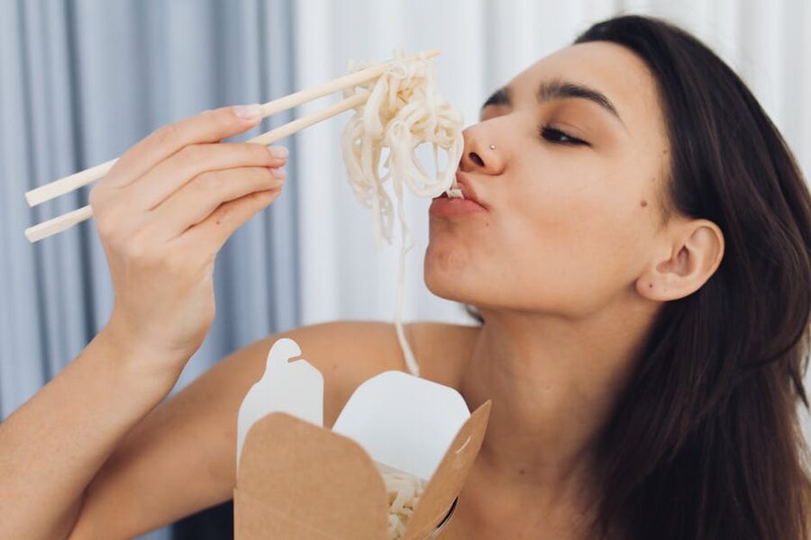 Woman eating ramen with chopsticks
