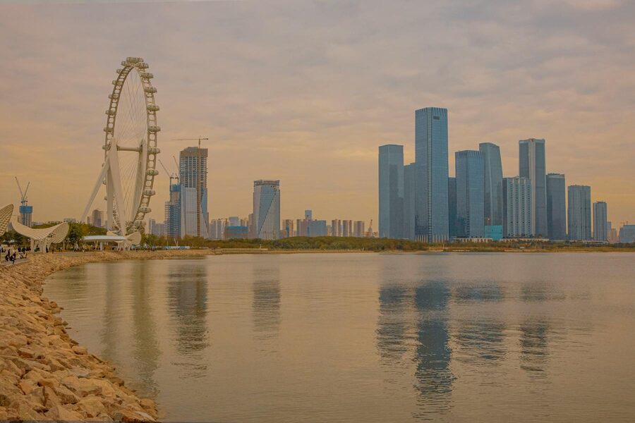 Shenzhen skyline and Ferris wheel reflected in water at sunset