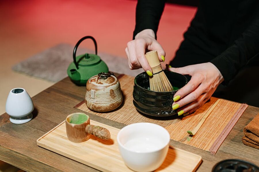 Hands preparing matcha tea in a Japanese tea ceremony