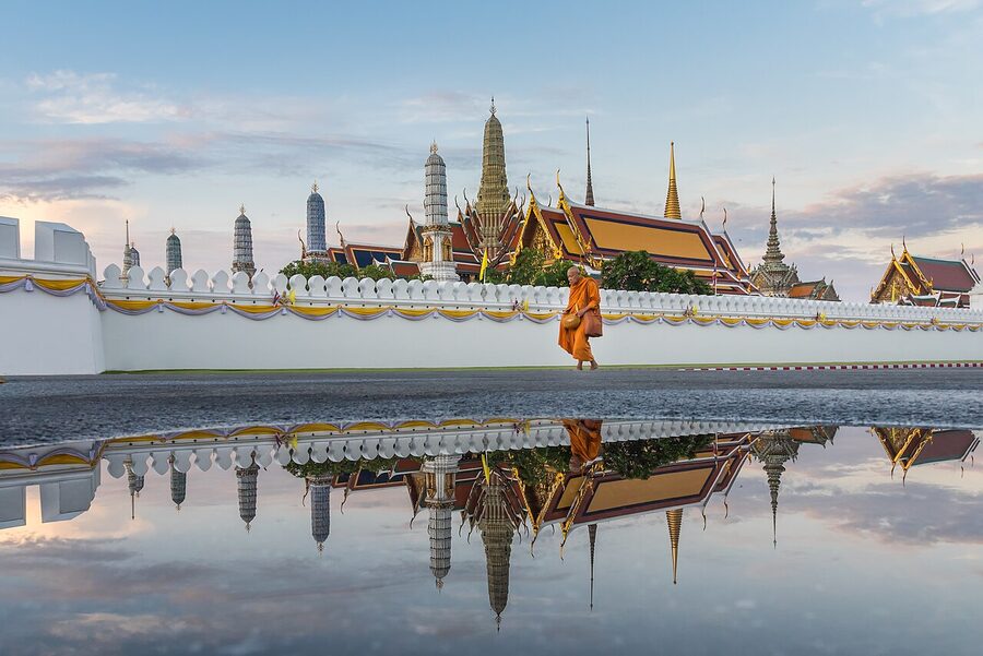 A monk walks in front of Temple of the Emerald Buddha, Wat Phra Kaew Bangkok