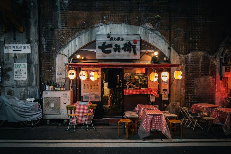 A warmly lit Tokyo izakaya with red lanterns at night