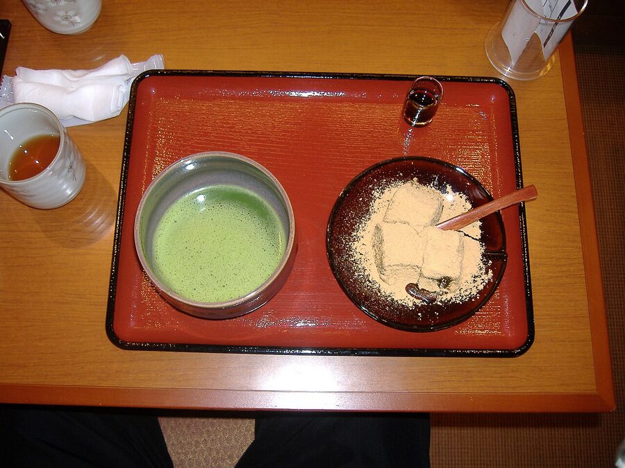 Matcha warabimochi dusted with kinako on a small dish in Kyoto