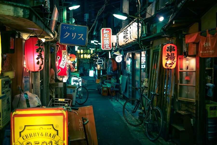 Narrow Tokyo yakitori alley after dark with red lanterns