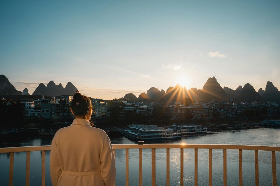 Woman enjoying sunrise view of Guilin karst mountains